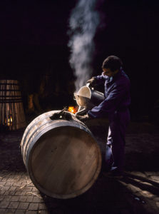 Pouring boiling water into a Portuguese oak barrel to clean it after assembly in the cooperage of Ferreira. Vila Nova de Gaia, Portugal. [Douro / Port] ©CEPHAS / Mick Rock