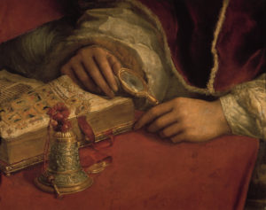 “Pope Leo X with the Cardinals Luigi Rosso and Giulio de’ Medici”. Detail: hands of the pope, reading glass, book and table bell ©akg-images / Erich Lessing