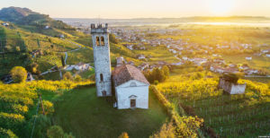 Italy, Veneto, Treviso district, Farra di Soligo, Prosecco Road, Aerial view at sunrise with San Lorenzo church ©Arcangelo Piai/4Corners Images