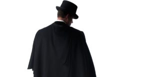 A Figurestock image of a mystery Victorian man in a cloak and hat, holding a knife, in silhouette - shot from eye level.