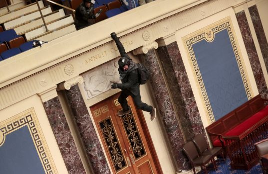 A protester is seen hanging from the balcony in the Senate Chamber on January 06, 2021 in Washington, DC.